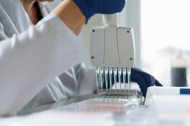 A laboratory scientist loading samples with a multichannel pipette